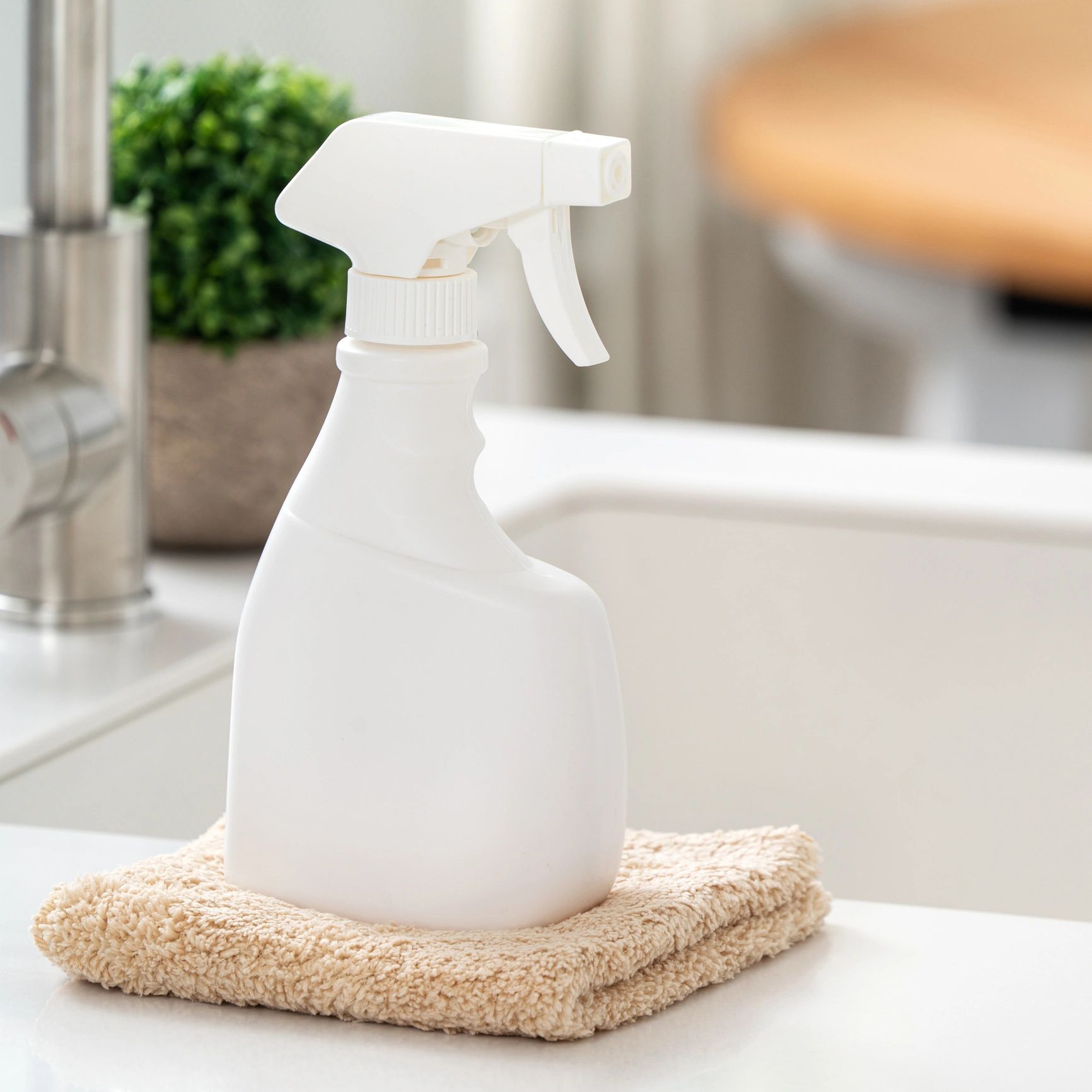 Cleaning spray bottle and microfiber cloth in a kitchen